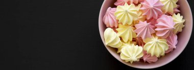 Mini meringues siyah arka plan, üstten görünüm üzerinde pembe bir kase. F