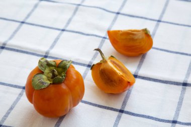 Kumaş, yan görünümü üzerine taze Trabzon hurması. Yakın çekim.