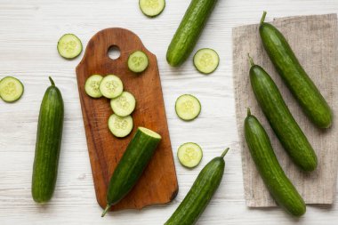 Beyaz ahşap arka plan, üstten görünüm üzerinde taze çiğ yeşil salatalık