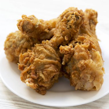 Kızarmış tavuk drumsticks tabakta yuvarlak beyaz, yan görünüm. Clos