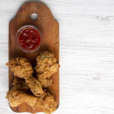 Kızarmış tavuk drumsticks ahşap tahtası beyaz üzerine ketçap ile