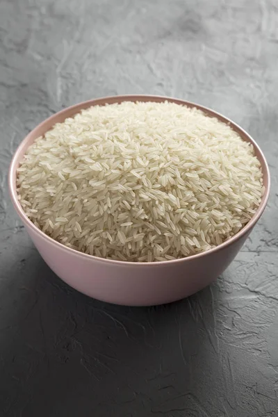 회색 배경, 사이드 위에 분홍색 그릇에 흰 쌀 건조 인도 — 스톡 사진