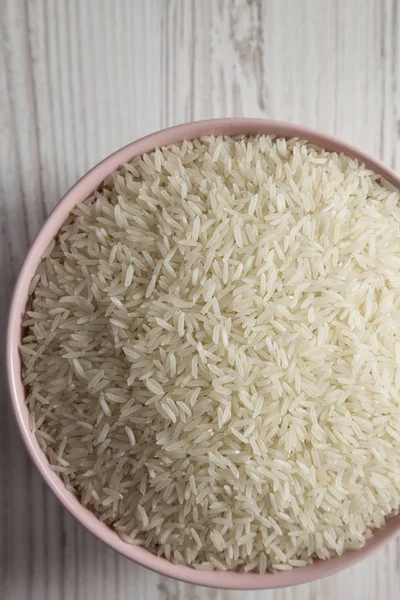 흰색 나무 backgrou에 분홍색 그릇에 흰 쌀 건조 인도 — 스톡 사진