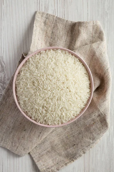 흰색 나무 backgrou에 분홍색 그릇에 흰 쌀 건조 인도 — 스톡 사진
