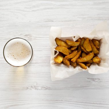 Kızarmış patates kağıt kutusu ve bir beyaz bira geri ahşap takozlar