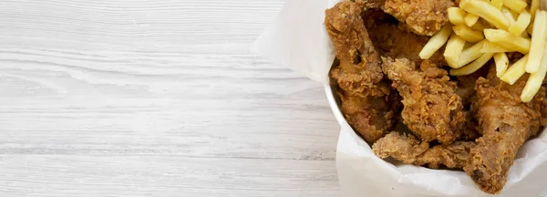 Snabbmat: stekta kycklingklubbor, kryddig vingar, pommes frites en — Stockfoto