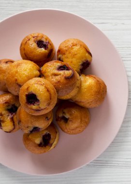 Pembe plaka üzerinde beyaz woode kiraz ile ev yapımı mini kekler