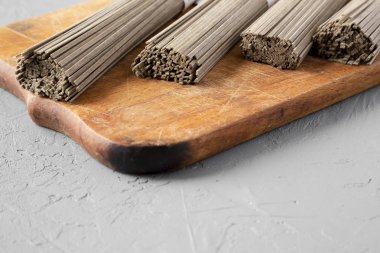 Kurutulmuş buğday soba noodle gri su üzerinde rustik ahşap tahta üzerinde