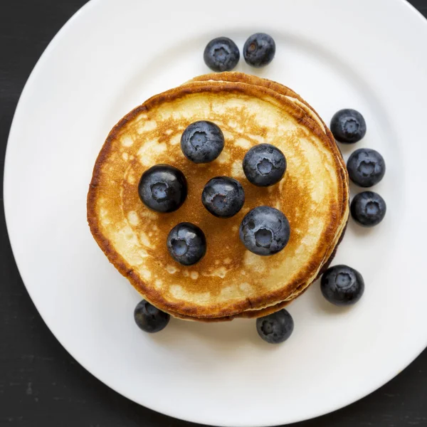Hausgemachte Pfannkuchen mit Blaubeeren auf einem weißen runden Teller über — Stockfoto