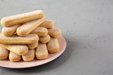 Savoiardi veya kedi dili kurabiye üzerinde pembe plaka üzerinde beton arka
