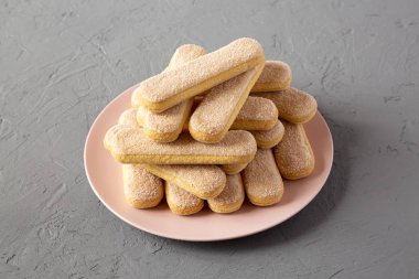 Savoiardi veya kedi dili kurabiye üzerinde pembe plaka üzerinde beton arka