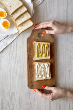 Kadın pişirir yumurta sandviç Kahvaltı, üstteki görünüm için adım adım. F
