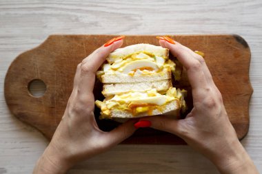 Kadın elleri ev yapımı yumurta sandviç, üst görünüm tutun.