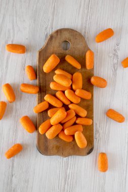 Beyaz ahşap arka üzerinde rustik ahşap tahta üzerinde taze bebek havuç