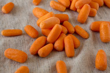 Tasty baby carrots on cloth, side view. Close-up. clipart