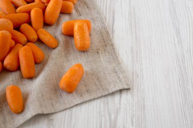 Tasty peeled baby carrots on cloth, side view. Copy space and te clipart