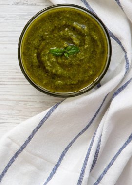 Basil pesto Beyaz ahşap yüzey üzerinde, üst görünüm. Düz yatma, izolatörler