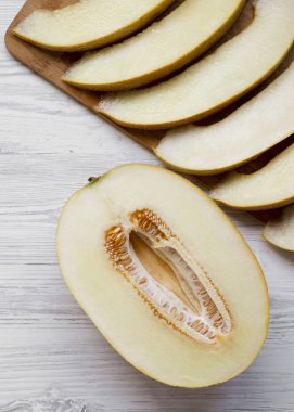Beyaz ahşap arka planda kavun dilimleri, tepegöz görünümü. Bir