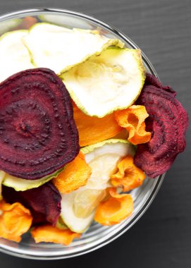 Siyah arka plan üzerinde bir kase içinde Veggie cips, üst görünüm. Memleketi ABO