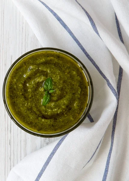 Basil pesto Beyaz ahşap arka plan üzerinde bir kase, üst görünüm. Fl