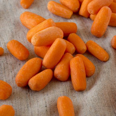 Peeled baby carrots on cloth, side view. Close-up. clipart