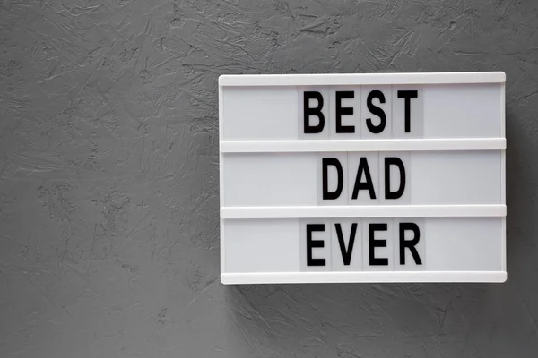 Modernes Brett mit den Worten "bester Papa aller Zeiten" vor grauem Hintergrund, um — Stockfoto