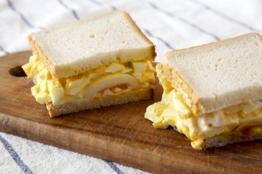 Ahşap tahta, düşük açı görünümü üzerinde ev yapımı yumurta salata sandviç. Clo