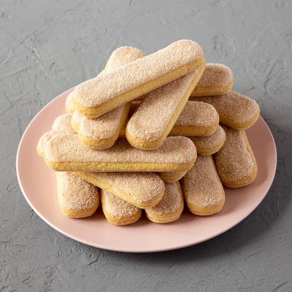 Gri backgroun pembe plaka üzerinde Savoyardi veya ladyfingers çerezleri