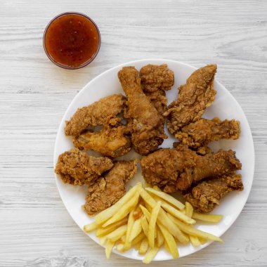 Lezzetli kızarmış tavuk bacakları, baharatlı kanatlar, patates kızartması, tavuk yüzgeci