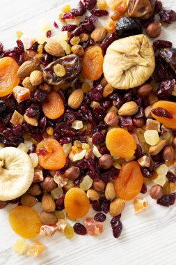 Beyaz ahşap bir arka plan üzerinde kurutulmuş meyve ve fındık karışımı, görünümü