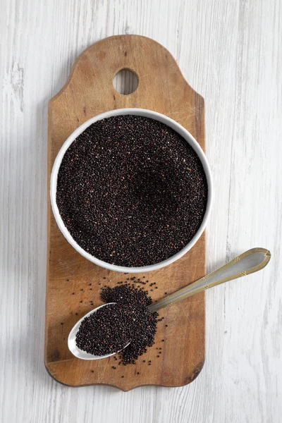 Glutenvrij rauwe organische zwarte quinoa op rustieke houten plank, Top — Stockfoto