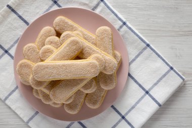 Beyaz ahşap üzerinde pembe plaka üzerinde Savoiardi veya kedi dili çerezler