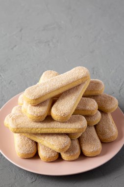 Gri bir backgro üzerinde pembe plaka üzerinde Savoiardi veya ladyfingers çerezleri