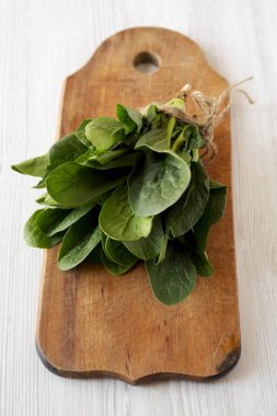 Rustik ahşap tahta, düşük açı görünümünde taze çiğ ıspanak. Yakın-