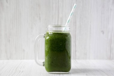 Cam bir kavanozda avokado, ıspanak ve muz ile yeşil yüzlü o