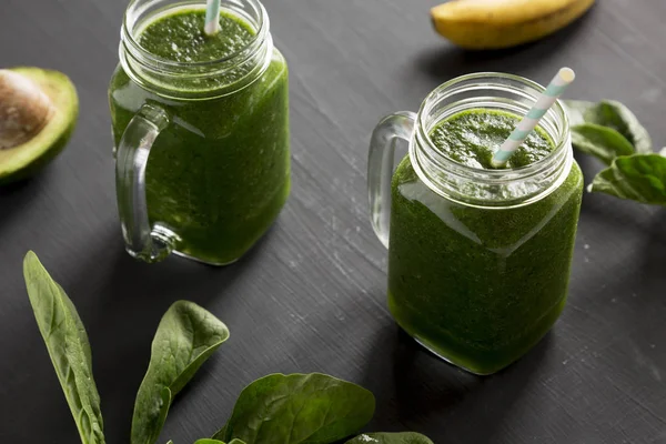 Batido verde con aguacate, espinacas y plátano en frascos de vidrio ov — Foto de Stock