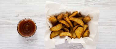 Kızarmış patates dilimleri kağıt kutusu ve Barbekü soslu beyaz w üzerinde