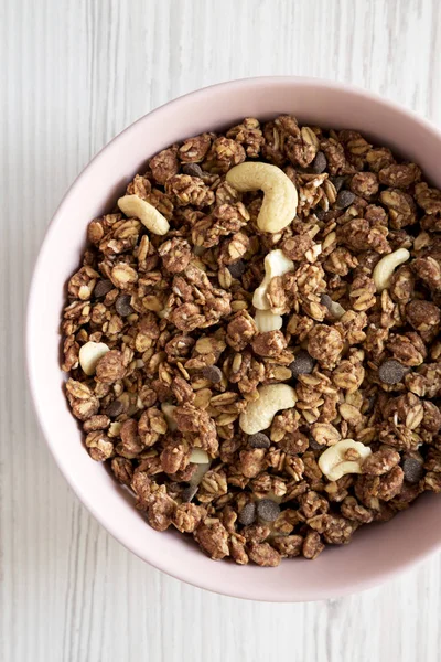 Homemade chocolate granola with nuts in a pink bowl over white w — Stock Photo, Image