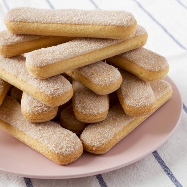 Savoiardi veya ladyfingers çerezleri bez üzerinde pembe bir tabak üzerinde, yan 
