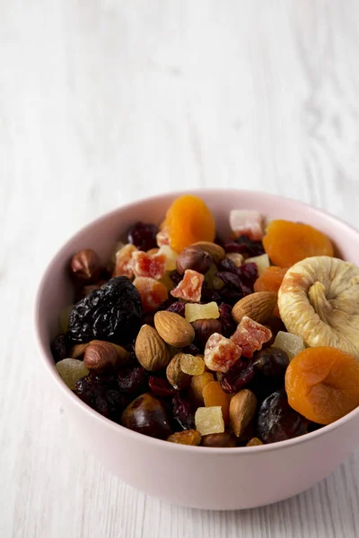 stock image Dried fruits and nuts in a pink bowl over white wooden surface, 