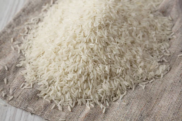 Basmati de arroz blanco seco sobre tela, vista lateral. Primer plano. . —  Fotos de Stock