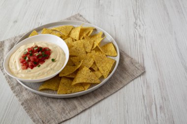 Bir kase, sarı tortilla cips, yan görünüm ev yapımı peynirli daldırma.