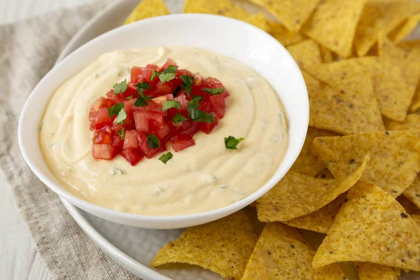 Bir kase, sarı tortilla cips, yan görünüm ev yapımı peynirli daldırma.