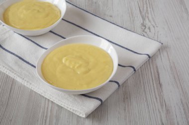 Beyaz kaselerde ev yapımı vanilyalı muhallebi puding, düşük açı görünümü.