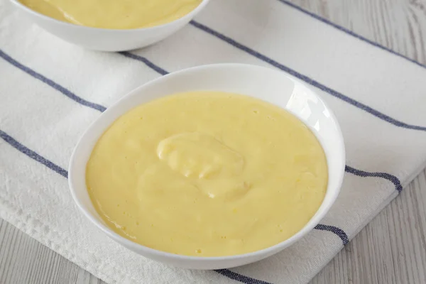 Zelfgemaakte vanille custard pudding in witte kommen, lage hoek uitzicht. — Stockfoto