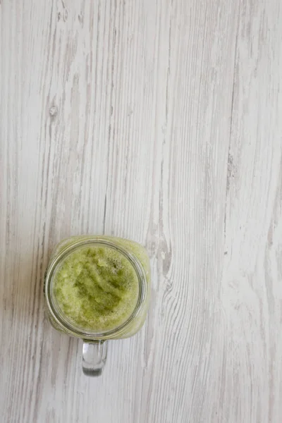 Зелена селера в скляній банці над білою дерев'яною поверхнею , — стокове фото