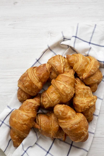 Fresh croissants on a white wooden background, top view. From ab — Stock Photo, Image