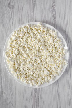 Beyaz tabakta ev yapımı süzme peynir, havai görünüm. Kaynak: ab