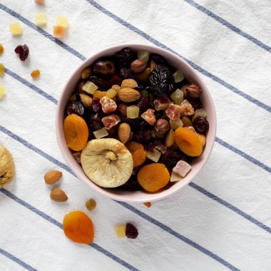 Üst görünüm, kurutulmuş meyve ve fındık pembe bir kapta. Düz yatıyordu, bir