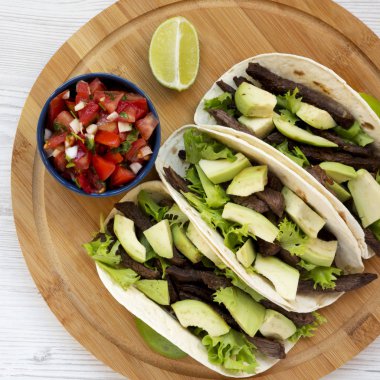 Mısır ekmeği ızgara sığır eti, avokado, kireç ve salsa bam üzerinde